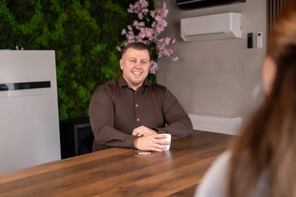 Lachende Giovanni Kokken van Jadikoel in gesprek met een klant aan de showroomtafel