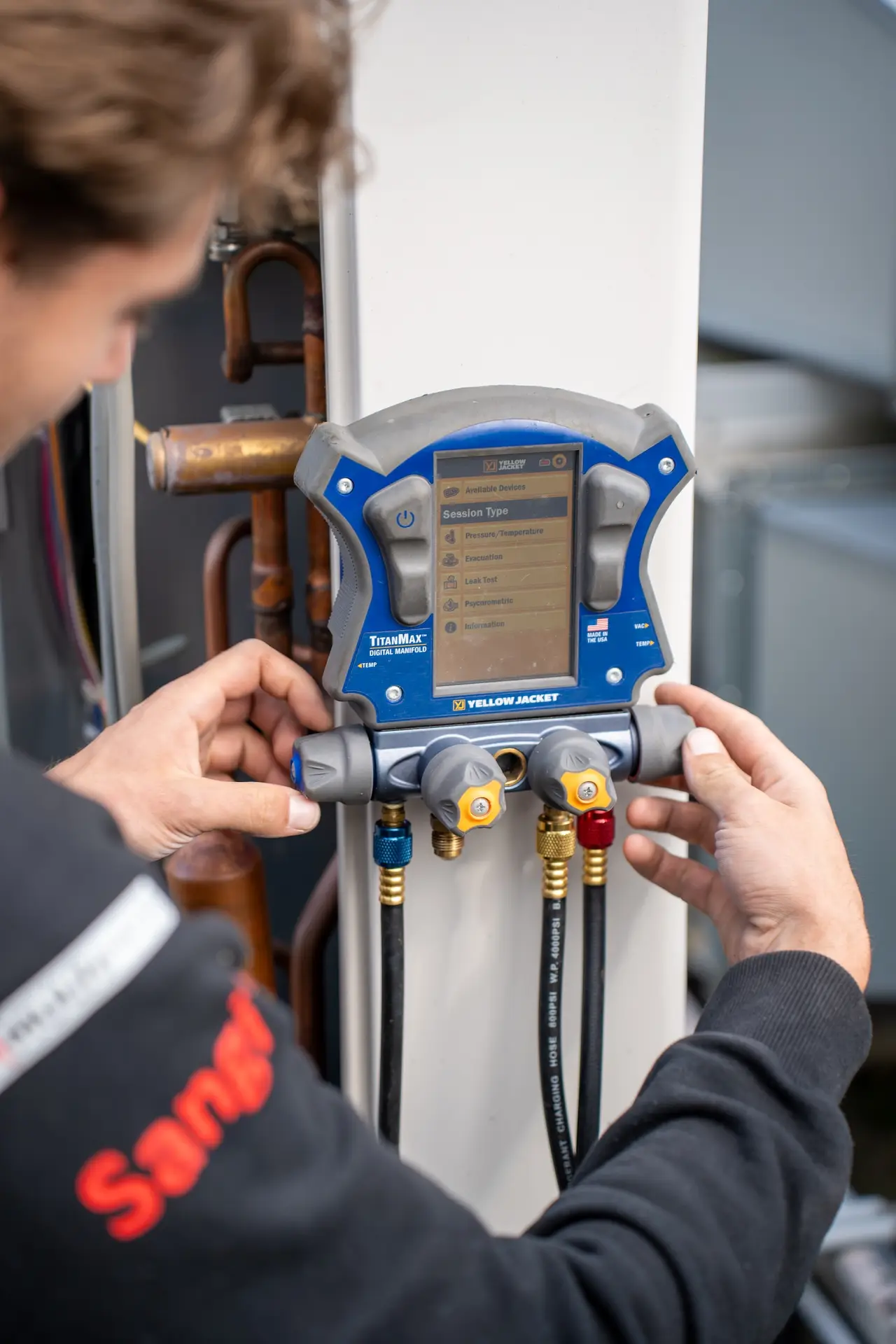 Monteur van Jadikoel sluit een digitale manifold aan om de koeldruk van een airco te meten