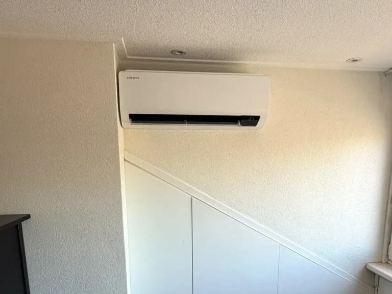 Samsung airco binnenunit boven een trapkast in een slaapkamer in Reeuwijk