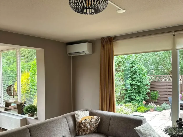 Panasonic airco binnenunit boven de schuifpui in een lichte woonkamer in Schoonhoven