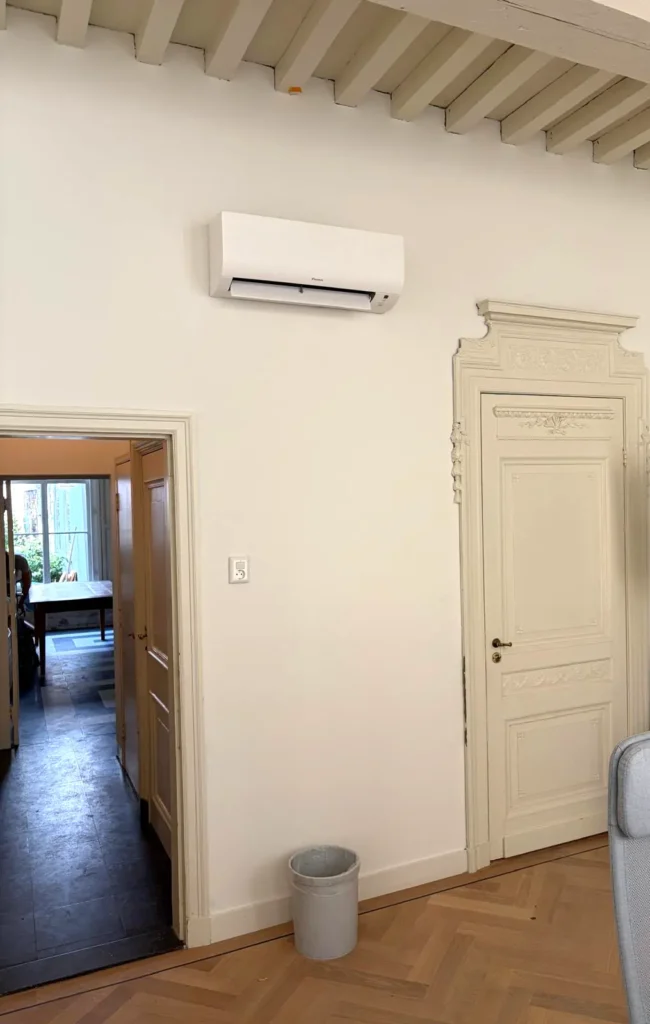 Daikin airco wandunit naast een monumentale deur met ornamenten in een kantoorpand in Den Haag