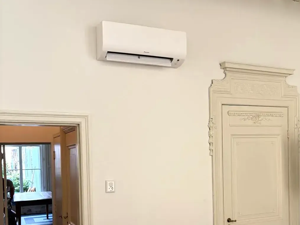 Daikin airco wandunit naast een monumentale deur met ornamenten in een kantoorpand in Den Haag