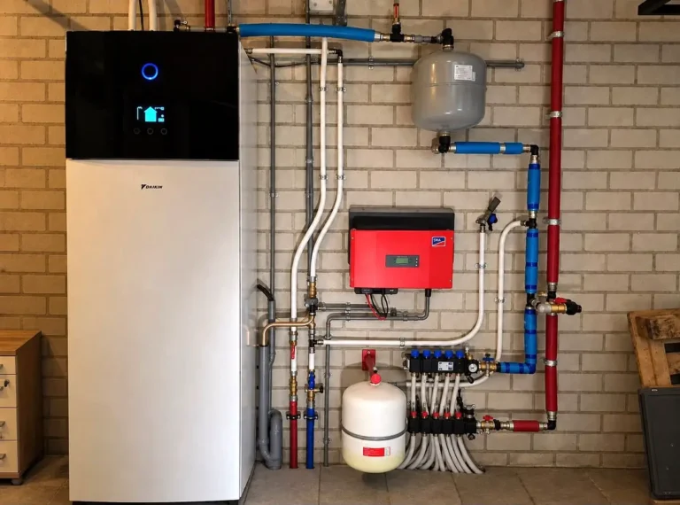 Daikin warmtepomp binnenunit met netjes aangelegd leidingwerk, expansievaten en vloerverwarmingsverdeler in een woning in Utrecht